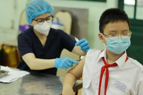 Nhân viên y tế tiêm vaccine phòng COVID-19 cho học sinh trường Trung học Cơ sở Hồng Bàng, quận 5. (Ảnh: Thu Hương/TTXVN)
