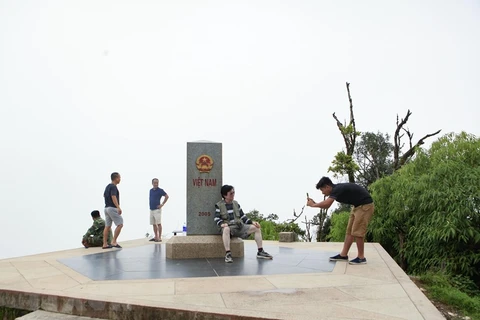 Du khách tham quan, chụp ảnh lưu niệm bên cột mốc số 0 A Pa Chải nằm trên đỉnh Khoan La San, xã Sín Thầu, huyện Mường Nhé, tỉnh Điện Biên. (Ảnh: Xuân Tư/TTXVN)