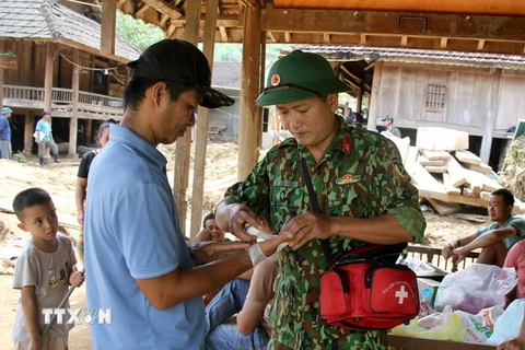 Nhân viên Quân y, Bộ chỉ huy Quân sự tỉnh Nghệ An thăm khám, cấp phát thuốc cho nhân dân vùng lũ ở huyện Kỳ Sơn. (Ảnh: Văn Tý/TTXVN)