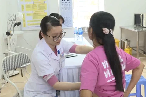 Bác sỹ thực hiện khám sàng lọc phát hiện sớm ung thư vú cho người dân. (Ảnh: PV/Vietnam+)