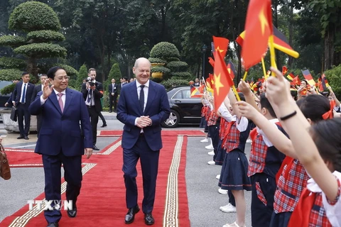 Thủ tướng Phạm Minh Chính và Thủ tướng Đức Olaf Scholz với thiếu nhi Hà Nội tại Lễ đón chính thức. (Ảnh: Lâm Khánh/TTXVN)