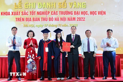 Đại diện Thủ khoa xuất sắc trao lại Sổ vàng cho Phó Bí thư Thành đoàn Hà Nội Nguyễn Tiến Hưng. (Ảnh: Minh Đức/TTXVN)