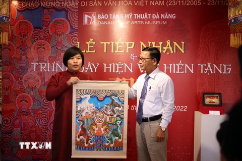 Nhà nghiên cứu, sưu tầm Nguyễn Thị Thu Hòa (trái) trao tặng các hiện vật cho ông Hà Thanh Vân, Giám đốc Bảo tàng Mỹ thuật Đà Nẵng. (Ảnh: Trần Lê Lâm/TTXVN)