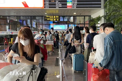 Hành khách xếp hàng chờ vào làm thủ tục chuyến bay tại Cảng Hàng không quốc tế Tân Sơn Nhất, Thành phố Hồ Chí Minh. (Ảnh: Tiến Lực/TTXVN)