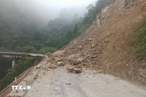 Hàng trăm khối đất, đá trên núi đổ xuống gây ách tắc trên tuyến Quốc lộ 8A, đoạn qua xã Sơn Kim 1. (Ảnh: TTXVN phát)