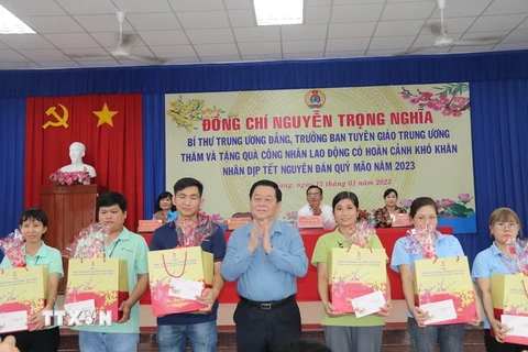 Trưởng ban Tuyên giáo Trung ương Nguyễn Trọng Nghĩa tặng quà công nhân lao động huyện Châu Thành. (Ảnh: Minh Trí/TTXVN)