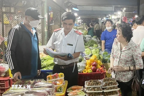 Đoàn kiểm tra Ban Quản lý an toàn thực phẩm Thành phố Hồ Chí Minh kiểm tra rau củ quả tại một chợ đầu mối nông sản trong thành phố. (Ảnh: TTXVN phát)