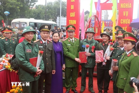 Trung tướng Nguyễn Duy Ngọc, Thứ trưởng Bộ Công an và Bí thư Tỉnh ủy Hà Nam Lê Thị Thủy tặng hoa, tặng quà cho tân binh. (Ảnh: Thanh Tuấn/TTXVN)