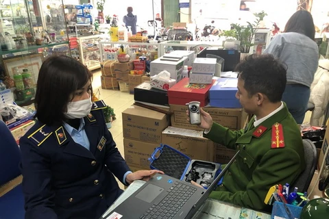 Lực lượng chức năng đang kiểm tra thiết bị đo nồng độ cồn tại cửa hàng kinh doanh thiết bị y tế trên phố Phương Mai. (Ảnh: Uyên Hương/BNEWS/TTXVN)