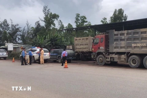 Lực lượng chức năng kiểm tra đoàn xe tải nghi làm giả tem kiểm định của công ty Nam Tiến. (Ảnh: TTXVN phát)