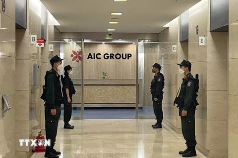 Lực lượng Cảnh sát điều tra làm nhiệm bảo vệ trong quá trình khám xét tại trụ sở Công ty AIC, 69 phố Tuệ Tĩnh, ngày 29/4/2022. (Ảnh: Phạm Kiên/TTXVN)