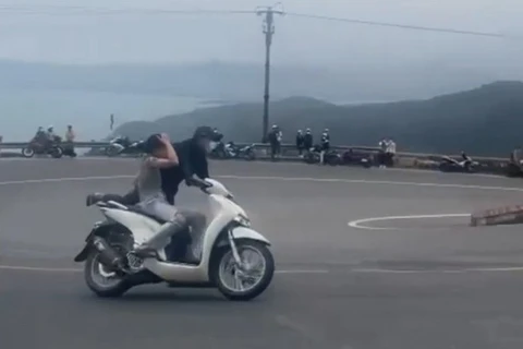 Đôi nam nữ chạy xe máy "làm xiếc" trên đèo Hải Vân khiến cộng đồng mạng xôn xao. (Nguồn: cắt từ clip)