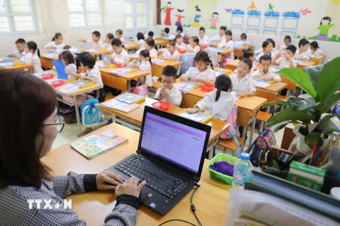 Cô và trò Trường Tiểu học Tân Định, quận Hoàng Mai, Hà Nội, trong một giờ học. (Ảnh: Thanh Tùng/TTXVN)