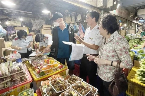 Đoàn kiểm tra Ban Quản lý an toàn thực phẩm Thành phố Hồ Chí Minh kiểm tra rau củ quả tại chợ đầu mối nông sản Thủ Đức. (Ảnh: TTXVN phát)