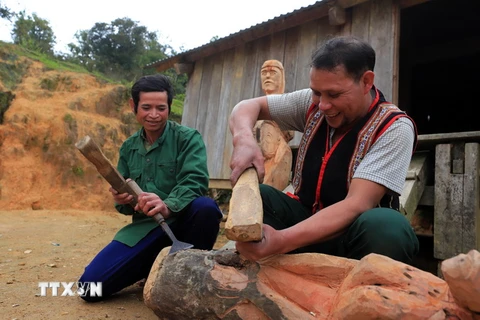 Nghệ nhân ưu tú A Gông (phải) truyền dạy kỹ năng tạc tượng gỗ của người Mơ Nâm cho thanh niên tại làng Kon Du, xã Măng Cành, huyện Kon Plông, tỉnh Kon Tum. (Ảnh: Khoa Chương/TTXVN)