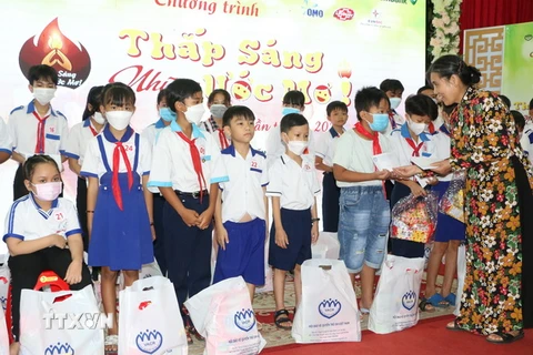 Chủ tịch Hội Bảo vệ quyền trẻ em Việt Nam Nguyễn Thị Thanh Hòa trao học bổng cho trẻ em tại chương trình. (Ảnh: Tuấn Kiệt/TTXVN)