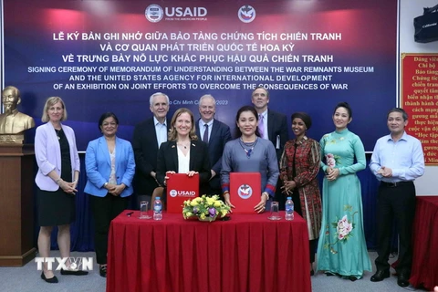 Bà Aler Grubbs, Giám đốc Quốc gia USAID tại Việt Nam và bà Trần Xuân Thảo, Giám đốc Bảo tàng Chứng tích Chiến tranh ký thỏa thuận hợp tác về trưng bày nỗ lực khắc phục hậu quả chiến tranh. (Ảnh: Xuân Khu/TTXVN)