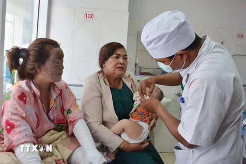 Bác sỹ thăm khám, điều trị, chăm sóc cho cháu bé 5 tháng tuổi bị bỏng do vụ nổ bình gas mini ở Đắk Lắk. (Ảnh: Hoài Thu/TTXVN)