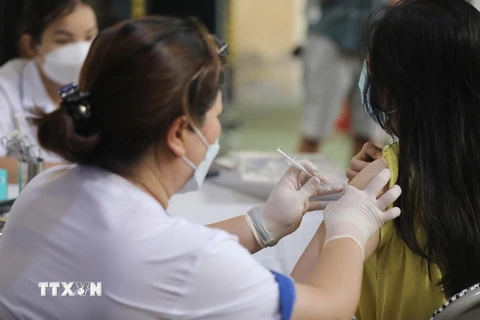 Nhân viên y tế tiêm vaccine cho học sinh. (Ảnh: Minh Quyết/TTXVN)