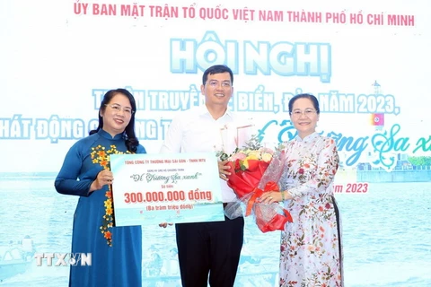 Bà Nguyễn Thị Lệ (bên phải), Phó Bí thư, Chủ tịch HĐND TP.HCM và bà Trần Kim Yến, Chủ tịch Ủy ban MTTQ Việt Nam TP.HCM tiếp nhận tượng trương ủng hộ chương trình "Vì Trường Sa xanh." (Ảnh: Xuân Khu/TTXVN)