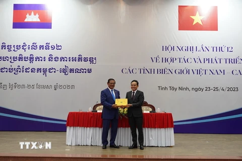 Phó Thủ tướng Chính phủ Trần Lưu Quang (phải) và Phó Thủ tướng, Bộ trưởng Bộ Nội vụ Vương quốc Campuchia Samdech Krolahom Sar Kheng tặng quà lưu niệm tại Hội nghị. (Ảnh: Thanh Tân/TTXVN)