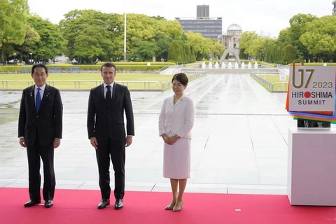 Tổng thống Pháp Emmanuel Macron chụp ảnh với Thủ tướng Nhật Bản Fumio Kishida và phu nhân Yuko Kishida tại Công viên Tưởng niệm Hòa bình trong chuyến dự Hội nghị thượng đỉnh G7 ở Hiroshima, Nhật Bản, ngày 19/5. (Nguồn: Reuters)