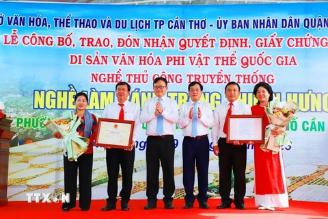 Đại diện lãnh đạo UBND thành phố Cần Thơ trao quyết định Di sản Văn hóa phi Vật thể Quốc gia Làng nghề làm bánh tráng Thuận Hưng cho đại diện chính quyền địa phương. (Ảnh: TTXVN phát)