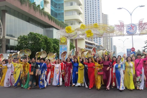 Phụ nữ tỉnh Khánh Hòa diễu hành trên phố với trang phục áo dài truyền thống và nón lá. (Ảnh: Phan Sáu /TTXVN) 