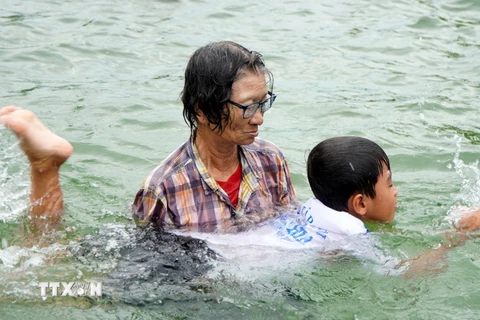Bà Trần Thị Kim Thia dạy cho trẻ động tác bơi. (Ảnh: Nhựt An/TTXVN)