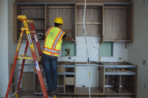 Một người thợ lắp đặt tủ bếp trong căn hộ một tòa nhà đang xây dựng ở New York. (Nguồn: Bloomberg)
