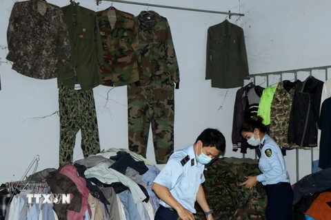 Lực lượng chức năng kiểm tra hàng hóa là quần áo rằn ri tại số 183 đường Hùng Vương, thị trấn Đăk Hà, huyện Đăk Hà, tỉnh Kon Tum. (Ảnh: Cao Nguyên/TTXVN)
