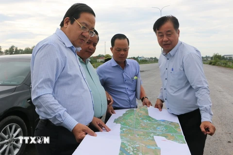 Phó Chủ tịch UBND tỉnh Long An Nguyễn Minh Lâm (trái) xem bản đồ đường Vành đai 3 Thành phố Hồ Chí Minh qua địa bàn tỉnh. (Ảnh: Thanh Bình/TTXVN)