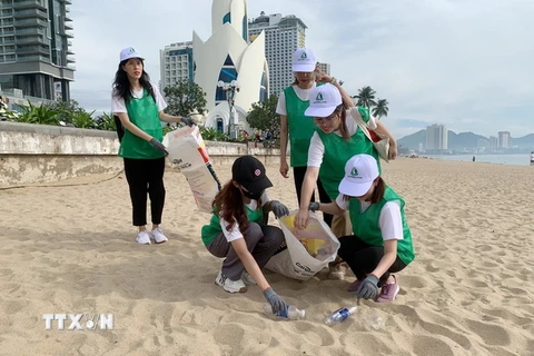 Một nhóm bạn trẻ tham gia dọn vệ sinh bãi biển Nha Trang sau lễ phát động chương trình "Hành động xanh-Vì tương lai xanh," tại Khánh Hòa. (Ảnh: Tiên Minh/TTXVN)