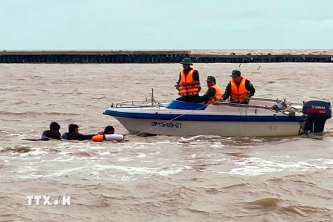 Lực lượng Bộ đội Biên phòng Cà Mau tiếp cận, cứu vớt 3 người trôi dạt trên biển đưa vào bờ an toàn. (Ảnh: TTXVN phát)