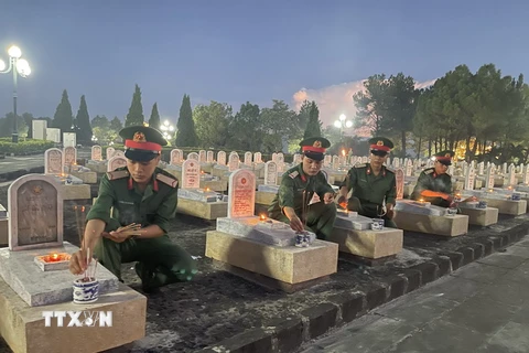 Đoàn viên, thanh niên của các lực lượng thắp nến tại các phần mộ của Nghĩa trang Liệt sỹ Quốc gia Đường 9. (Ảnh: Thanh Thủy/TTXVN)