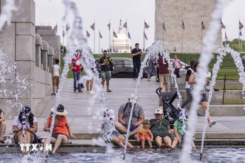 Người dân tránh nóng bên đài phun nước tại Washington, D.C., Mỹ, ngày 11/7 vừa qua. (Ảnh: THX/TTXVN)