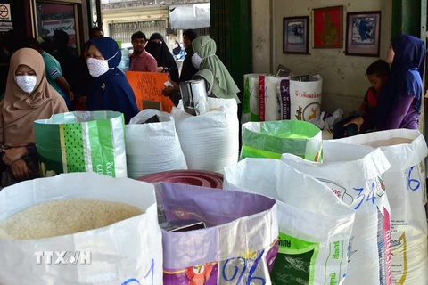 Người dân xếp hàng chờ mua gạo. (Ảnh: AFP/TTXVN)