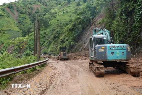 Công ty Cổ phần Xây dựng đường bộ I tập trung huy động máy xúc đất tại điểm sạt lở ở đoạn đường từ xã Khao Mang đi Hồ Bốn, huyện Mù Cang Chải, tỉnh Yên Bái. (Ảnh: Tuấn Anh/TTXVN)