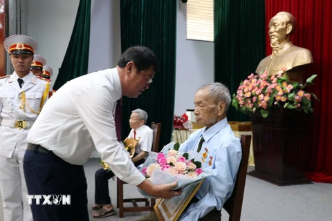 Bí thư Thành ủy Vũng Tàu Trần Đình Khoa tặng hoa cho đảng viên 65 năm tuổi Đảng. (Ảnh: Đoàn Mạnh Dương/TTXVN)