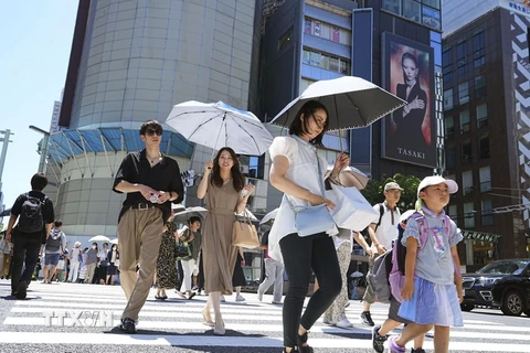 Người dân che ô tránh nắng nóng trên đường phố tại Tokyo của Nhật Bản. (Ảnh: Kyodo/TTXVN)