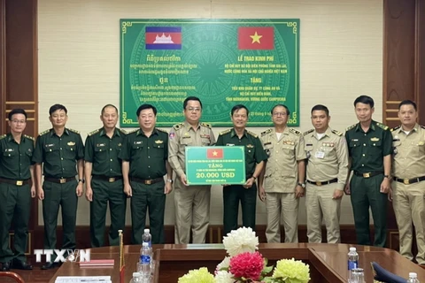 Đại tá Trần Tiến Hải, Chỉ huy trưởng Bộ đội Biên phòng tỉnh Gia Lai trao tặng kinh phí cho các lực lượng bảo vệ biên giới của tỉnh Ratanakiri, Vương quốc Campuchia. (Ảnh: TTXVN phát)