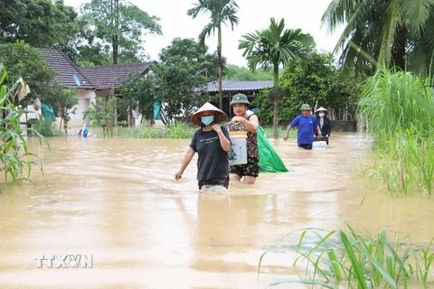 Người dân xã Yên Hợp, huyện Quỳ Hợp, tỉnh Nghệ An, giúp nhau vận chuyển tài sản, đồ đạc để tránh lũ tại các gia đình đã bị ngập nặng. (Ảnh: Xuân Tiến/TTXVN)