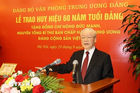 Tổng Bí thư Nguyễn Phú Trọng trao Huy hiệu 60 năm tuổi Đảng cho nguyên Tổng Bí thư Nông Đức Mạnh. (Ảnh: Trí Dũng/TTXVN)
