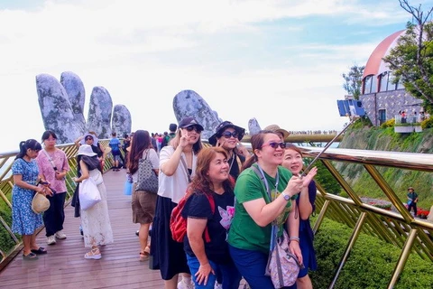 Khách du lịch quốc tế hào hứng check in với cầu Vàng tại Khu du lịch Sun World Ba Na Hills, thành phố Đà Nẵng. (Ảnh: Trần Lê Lâm/TTXVN)