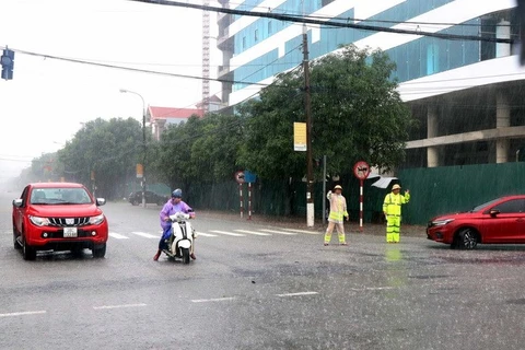 Lực lượng Cảnh sát Giao thông thành phố Hà Tĩnh phân luồng giao thông tại ngã tư đường Nguyễn Du và Trần Phú. (Ảnh: Công Tường/TTXVN)