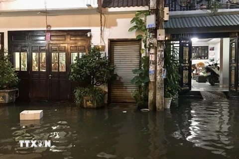 Nước ngập tràn vào nhà dân tại một tuyến hẻm trên đường Trần Xuân Soạn, quận 7, TP.HCM, chiều tối 1/10 vừa qua. (Ảnh: Hồng Giang/TTXVN)