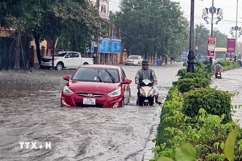 Nhiều phương tiện giao thông rất khó khăn khi lưu thông qua các tuyến đường ngập nước tại thành phố Đồng Hới, tỉnh Quảng Bình. (Ảnh: Tá Chuyên/TTXVN)