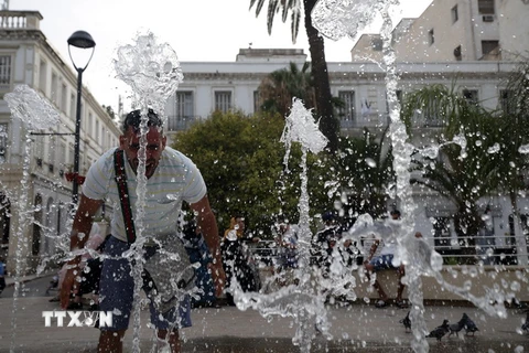 Người dân giải nhiệt tại một đài phun nước ở Algiers, Algeria ngày 10/7 vừa qua. (Ảnh: THX/TTXVN)