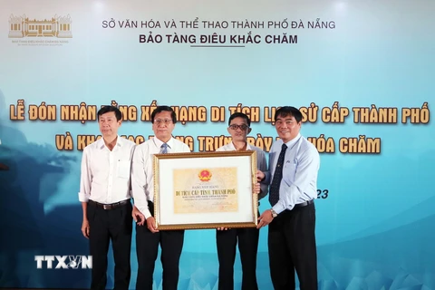 Phó Giám đốc Sở Văn hóa và Thể thao Đà Nẵng Nguyễn Trọng Thao (trái) trao Bằng xếp hạng Di tích Lịch sử cấp thành phố cho ông Hồ Tấn Tuấn, Giám đốc Bảo tàng Điêu khắc Chăm. (Ảnh: Trần Lê Lâm/TTXVN)