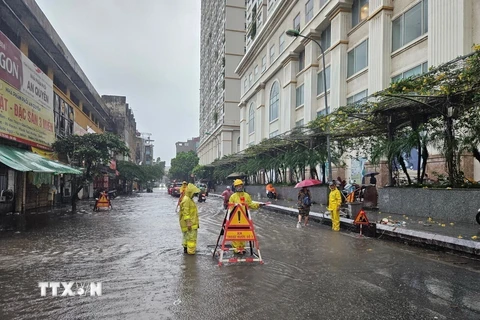 Công nhân Công ty Thoát nước Hà Nội ứng trực đảm bảo tiêu thoát khi mưa ngập. Ảnh: TTXVN phát